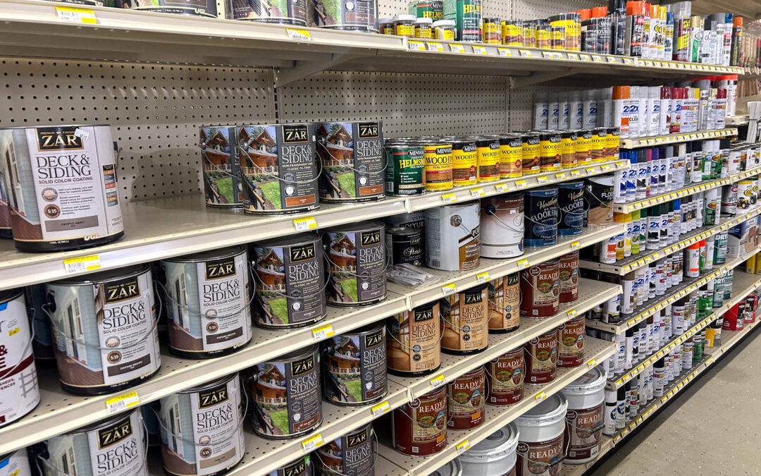 Shetler's Supplies Hardware Variety Bulk Foods Greenville PA Shelves stocked with various cans of paint, wood stains, and finishes in a hardware store aisle.