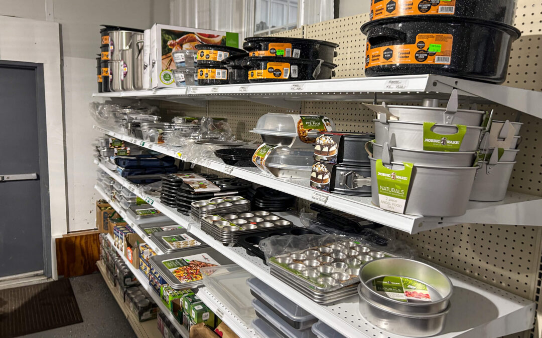 Shetler's Supplies Hardware Variety Bulk Foods Greenville PA Shelves in a store display various kitchen bakeware items including pans, trays, roasting dishes, and muffin tins, all neatly organized with packaging and labels visible.