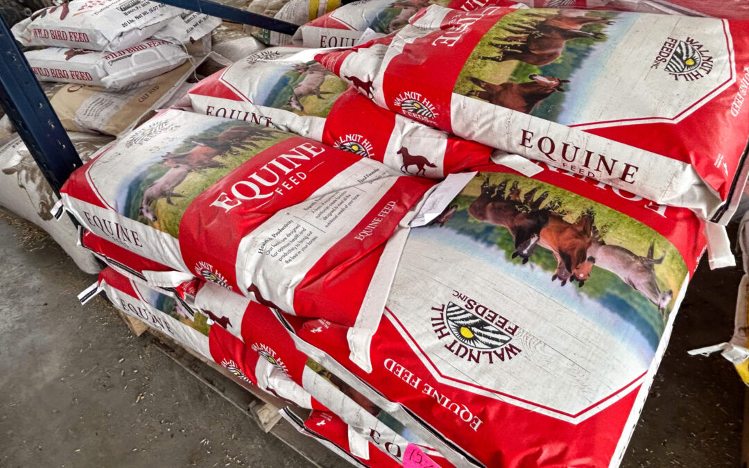 Shetler's Supplies Hardware Variety Bulk Foods Greenville PA Bags of red and white Equine Feed stacked on a pallet in a warehouse, featuring images of horses on the packaging.