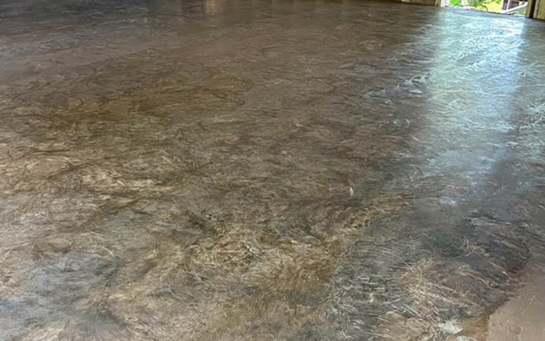 J&S Concrete Hawesville KY A concrete floor with a mottled finish inside a partially constructed building with exposed wooden wall studs and construction materials in the background.
