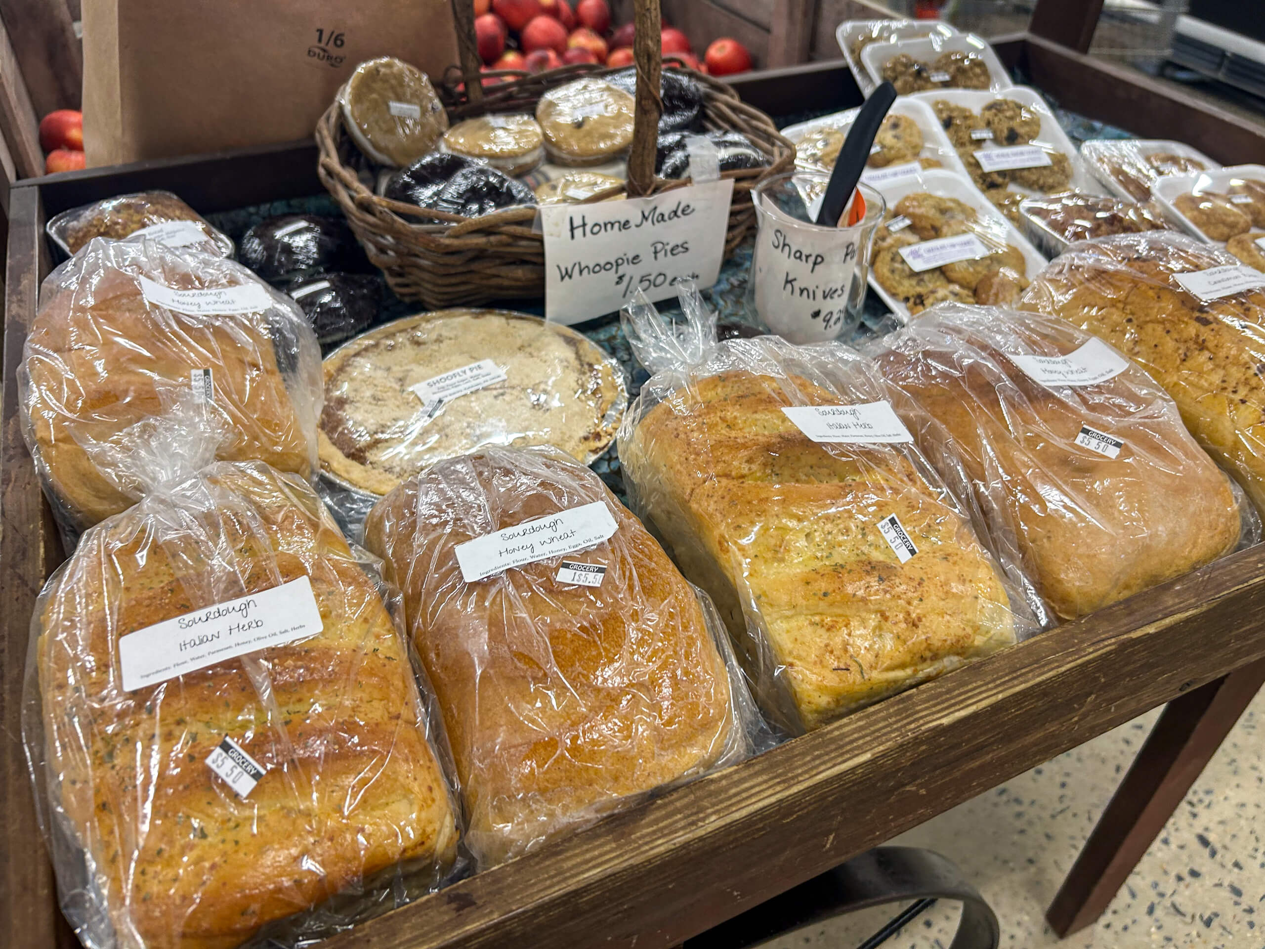 Jamar Groceries Kutztown PA Assorted loaves of bread and baked goods, including homemade whoopie pies, displayed on a wooden shelf at a market.
