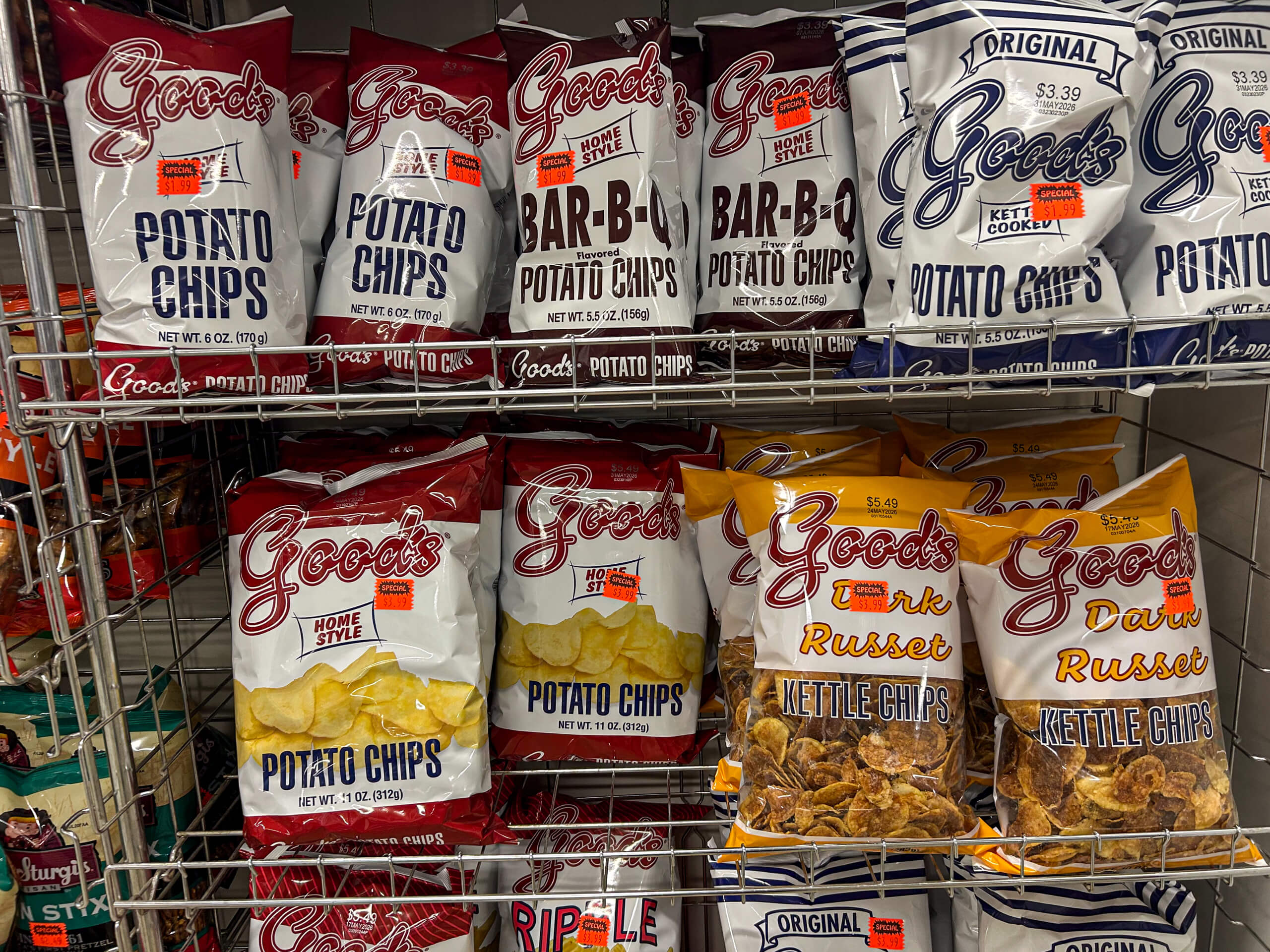 Jamar Groceries Kutztown PA Bags of Good’s brand potato chips and kettle cooked chips in various flavors are displayed on a metal grocery store shelf.
