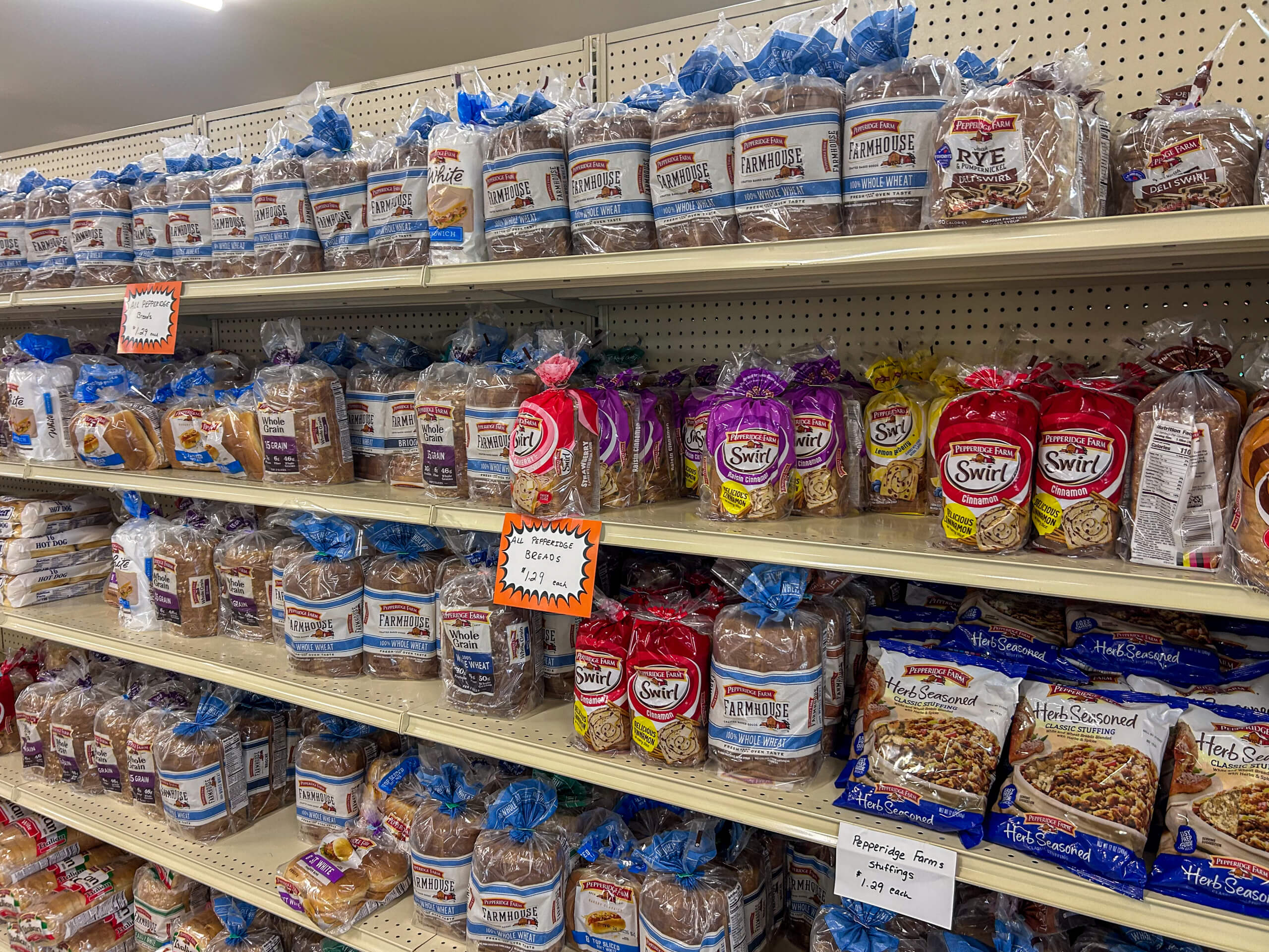 Jamar Groceries Kutztown PA Shelves in a grocery store display various brands and types of packaged bread, including whole wheat, rye, and swirl breads.