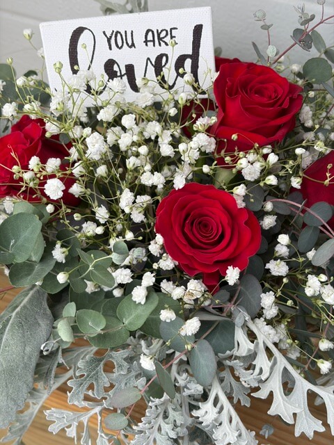 Swampy Hollow Greenhouse Gallery Cochranville, PA A bouquet of red roses, white baby's breath, and greenery includes a card that reads "You are loved.