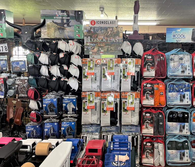 7.20.26 PenchPenchem Tack Store Guthrie, KYem Tack Store Gallery 3-3 Store display with horse tack, protective boots, cooling packs, stirrups, spurs, and various equestrian gear arranged on shelves and hooks.