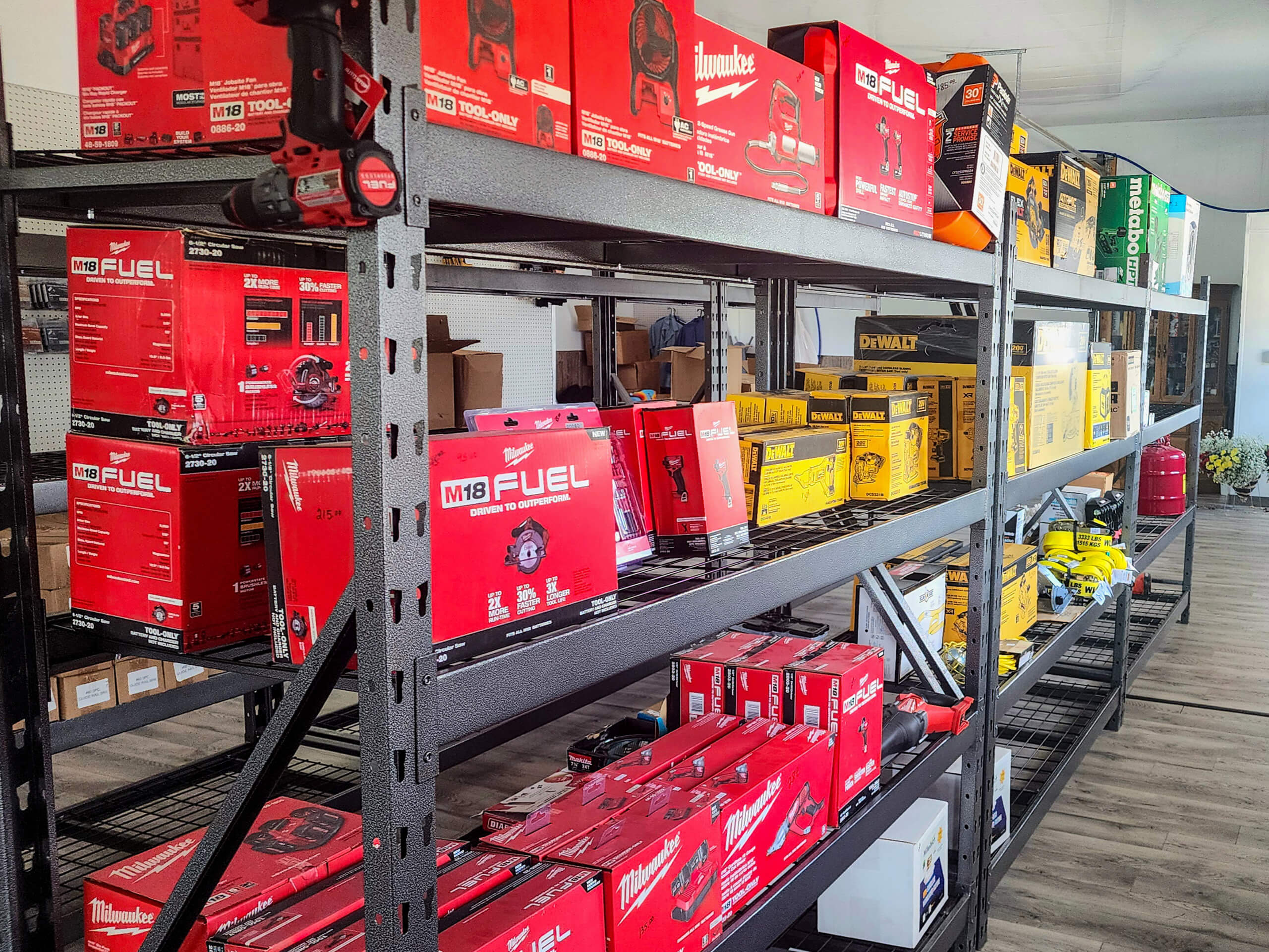 Sunset Metal Roofing and Siding Show Room Ebensburg, PA Shelves stocked with red Milwaukee tool boxes and yellow DeWalt tool boxes in a hardware store.